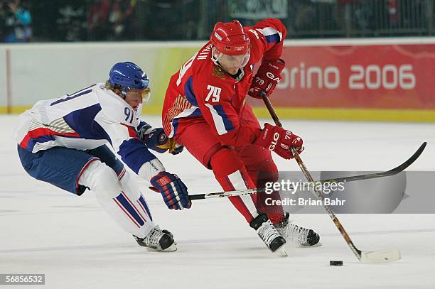 Alexei Yashin of tries to get around the defense of Marcel Hossa of Slovakia in the first period during the men's ice hockey Preliminary Round Group...