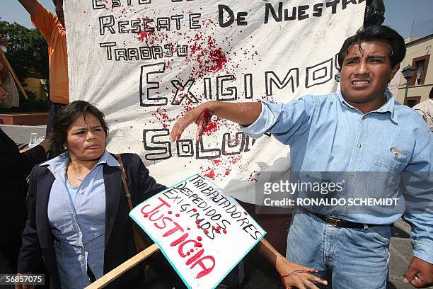Trabajadores despedidos del ayuntamiento de Puebla, a 180 km de Ciudad de Mexico, salpican su propia sangre en protesta contra el alcalde Enrique...