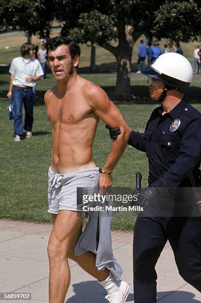 Man is apprehended by Los Angeles Police officers during a student protests against Nixon foreign policies involving the Vietnam war, circa 1970's at...