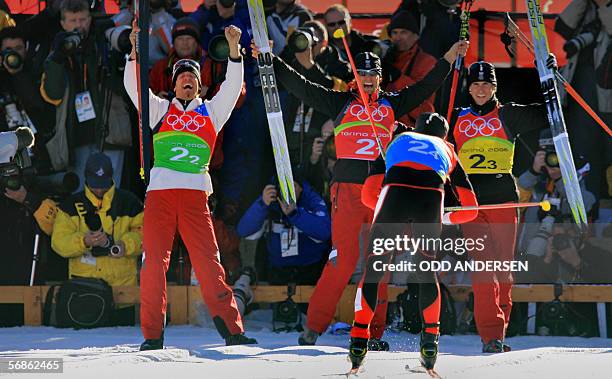 Austrian team members Christoph Bieler, Michael Gruber and Felix Gottwald cheer on their teammate Mario Stecher as he crosses the finish line of the...
