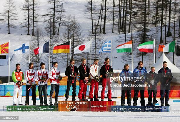 The German team, silver, the Austrian team, gold and the Finnish team, bronze, stand on the podium after the Nordic Combined 4x5km Team Final on Day...