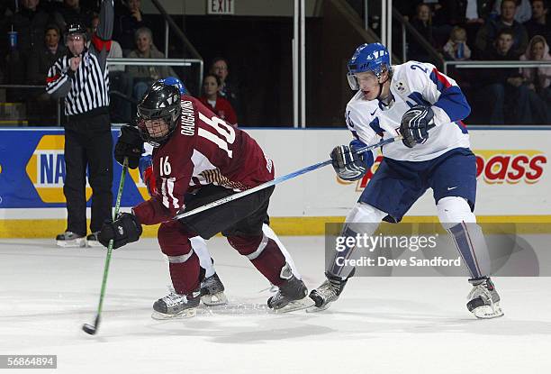 Kaspars Daugavins of Team Latvia skates the puck away from Erik Piatak of Team Slovakia during their World Junior Hockey Championship game at...