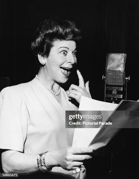 American actress, singer, and comedian Fanny Brice hams it up as she reads a script into a microphone as the title character, a bratty toddler, for...