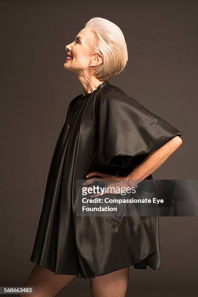 senior woman wearing black satin dress - satin dress stockfoto's en -beelden