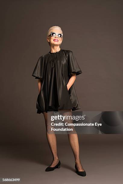 senior woman with sunglasses and black satin dress - woman satin dress stock pictures, royalty-free photos & images