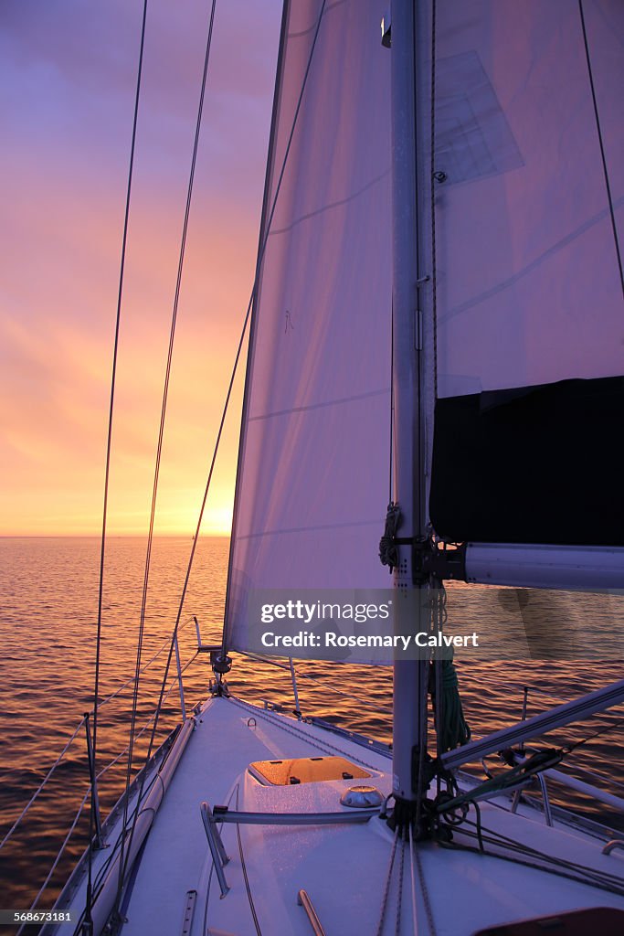 Glorious sunrise and yacht under sail