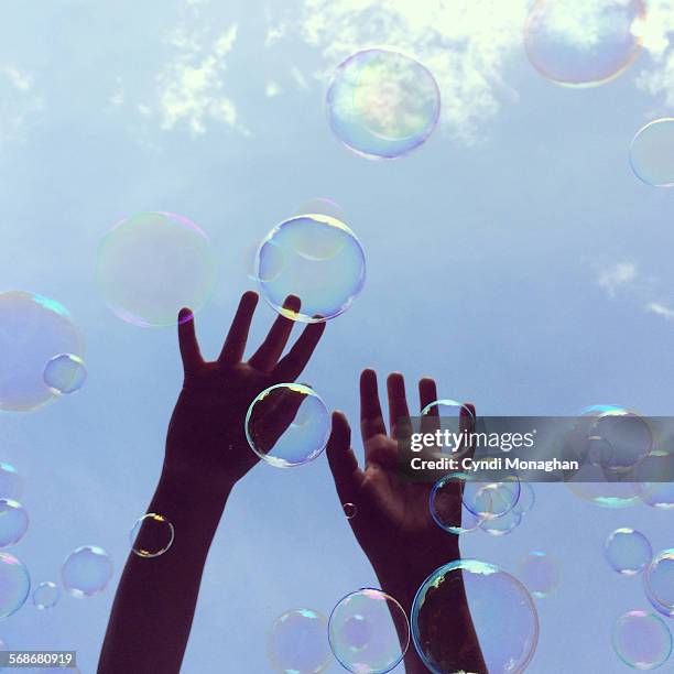 hands catching bubbles - bubble wand foto e immagini stock