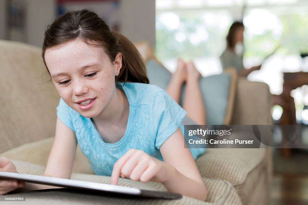 Girl on tablet at home sofa