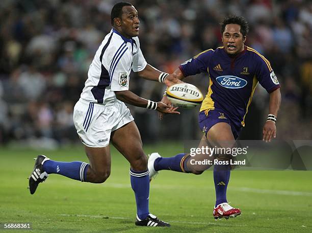 Joe Rokocoko of the Blues passes under pressure from Seilala Mapusua during the Round 2 Super 14 rugby match between the Highlanders and the Blues on...