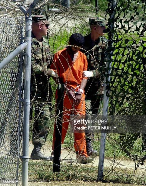 Picture taken 02 March 2002 shows a detainee being walked by two US Army MPs at Camp X-Ray in Guantanamo Bay, Cuba. British Prime Minister Tony Blair...