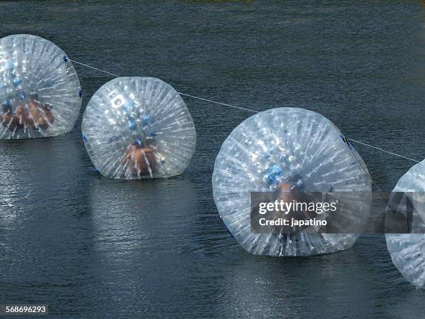 zorbing on water - water walking ball stock pictures, royalty-free photos & images