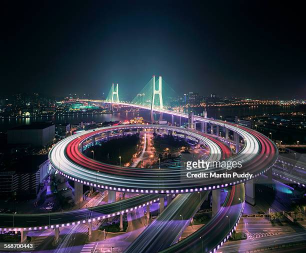 shanghai's nanpu bridge illuminated at night - urban traffic stock-fotos und bilder