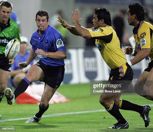 Matt Hodgson of the Western Force chips the ball past Tane Tu'ipulotu during the Round 2 Super 14 rugby match between the Hurricanes and the Western...