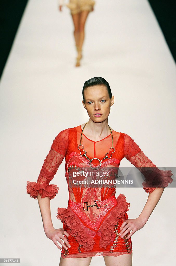 A model poses on the catwalk wearing clo