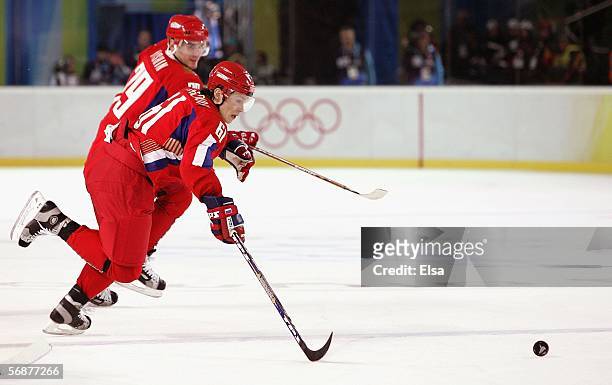 Maxim Afinogenov and Alexei Yashin of Russia pursue the puck during the second period of the men's ice hockey Preliminary Round Group B match against...