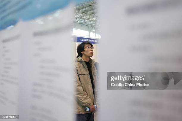 Job hunter looks at job information during an employment fair at the National Agriculture Exhibition Center on February 18, 2006 in Beijing, China....