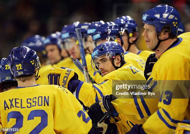 Per Johan Axelsson of Sweden celebrates with his teammates after he scored the fourth goal during the men's ice hockey Preliminary Round Group B...