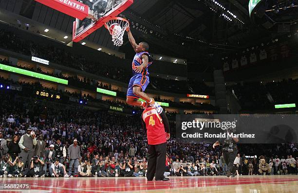 Nate Robinson of the New York Knicks goes up for a dunk over former slam dunk champion Spud Webb in the Sprite Rising Stars Slam Dunk competition...