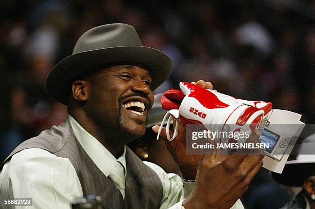 Houston, UNITED STATES: Miami Heat Shaquille O'Neal holds up a shoe video camera during the Slam-Dunk contest in the 2006 NBA All-Star events in...