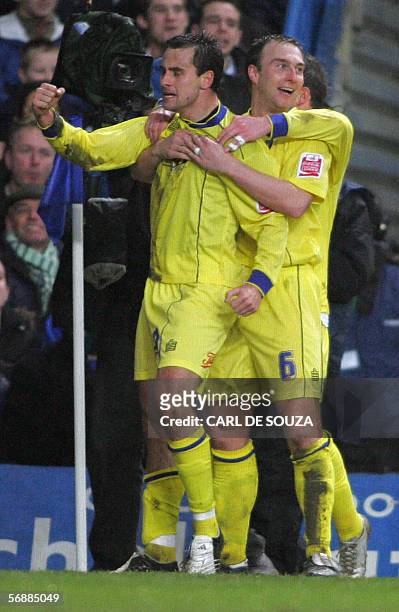 London, UNITED KINGDOM: Colchester's Richard Garcia and Kevin Watson celebrate after a deflected shot hit Chelsea's Ricardo Carvalho resulting in an...