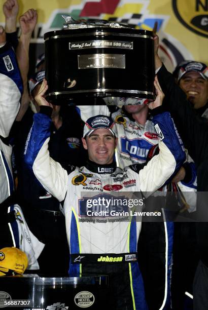 Jimmie Johnson, driver of the Lowe's Chevrolet, lifts up the winners trophy after victory during the NASCAR Nextel Cup Series Daytona 500 on February...