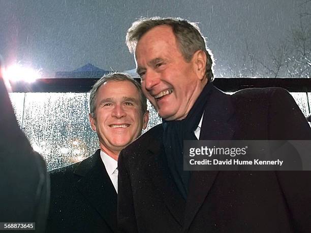 President George W. Bush in the Inaugural Parade stand in front of the White House jokes with his father former President George H.W. Bush during his...