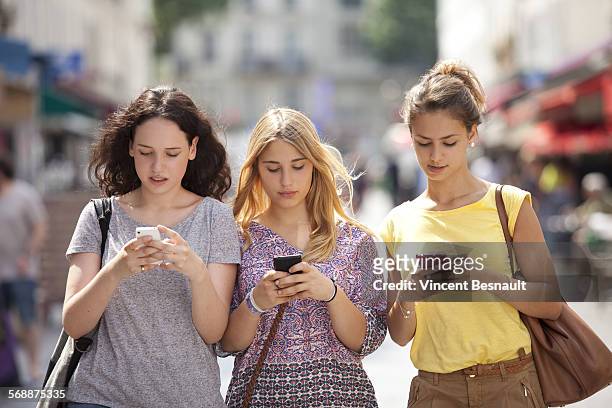 three girls with their mobile phone - vincent young stock pictures, royalty-free photos & images