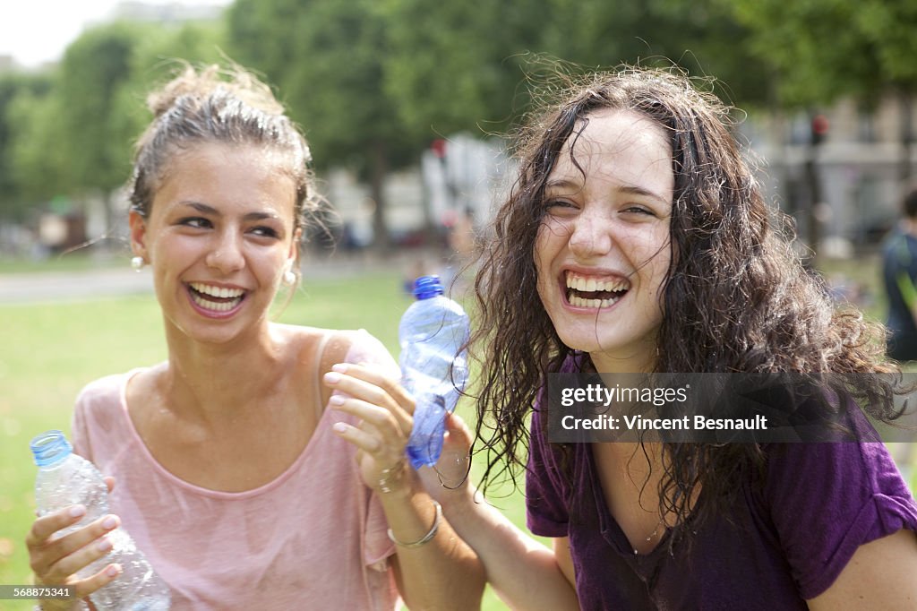 Two girls having fun with water in a park