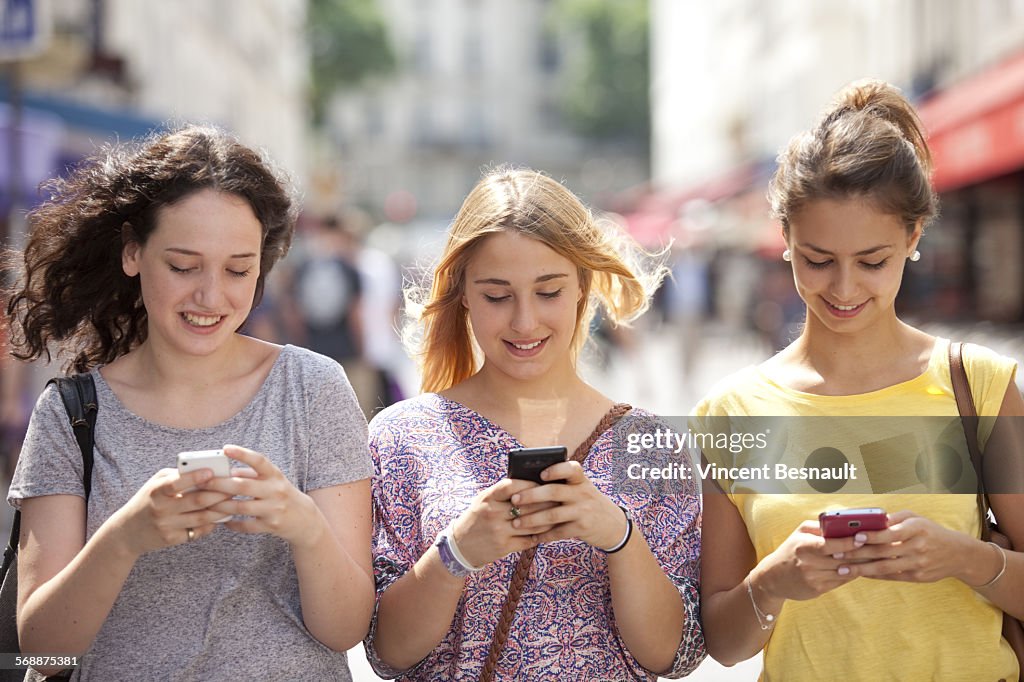 Three girls with their mobile phones