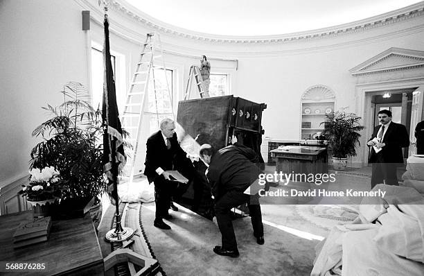 White House Head Usher Reex Scouten supervises the removal of former President Bush's desk, at the stroke of noon, from the Oval Office January 20,...