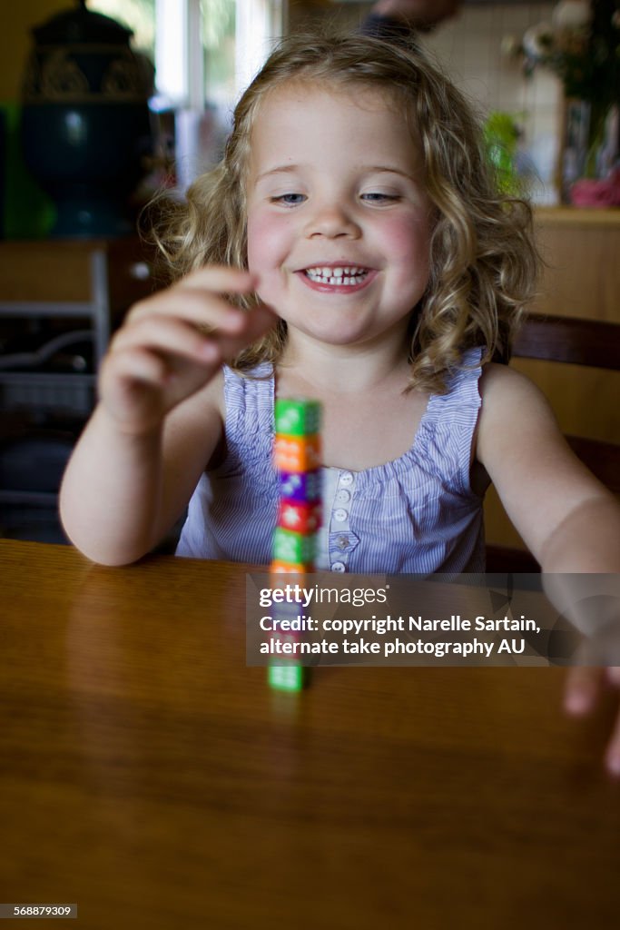 Young girl playing with dice tower