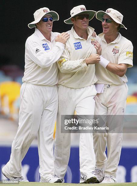 Daniel Doran, Matthew Hayden and Andy Bichel of the Bulls celebrate a wicket during day two of the Pura Cup match between the Queensland Bulls and...