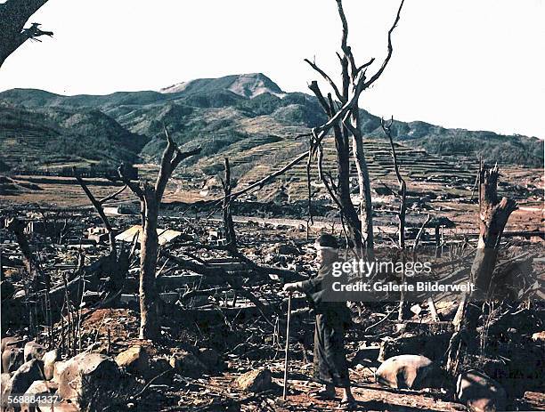Dr. Takashi Nagai of Nagasaki Hospital inspecting damage caused by the atomic bomb in the Matsuyama District. August 1945. The ruins of the Nagasaki...