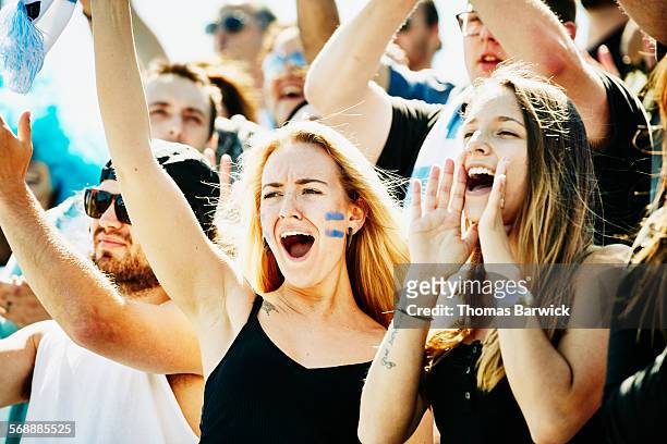 friends standing and yelling during soccer match - supporters photos et images de collection
