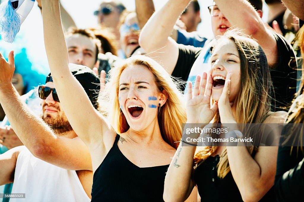 Friends standing and yelling during soccer match