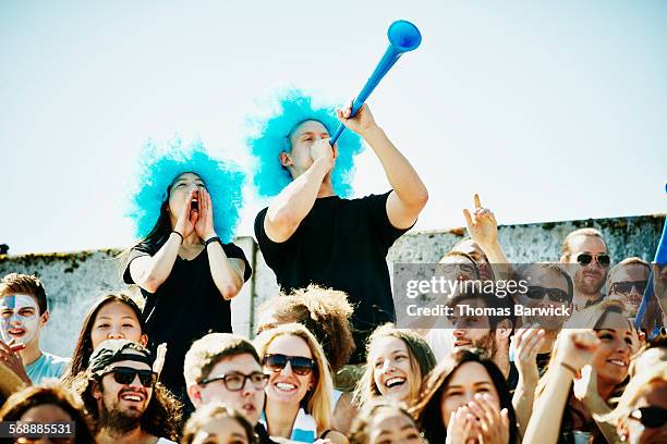 cheering couple in wigs standing in crowd - stadium 14 stock pictures, royalty-free photos & images