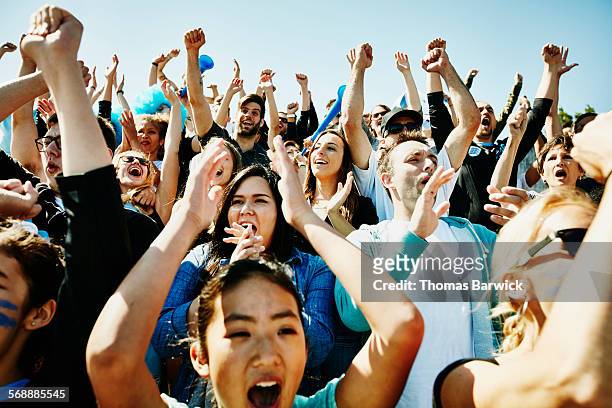 cheering crowd of soccer fans in stadium - fan enthusiast stock pictures, royalty-free photos & images
