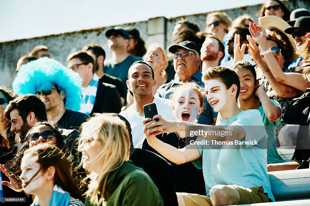 Young couple at soccer match taking selfie