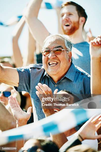 senior man cheering in crowd during soccer match - old american football - fotografias e filmes do acervo