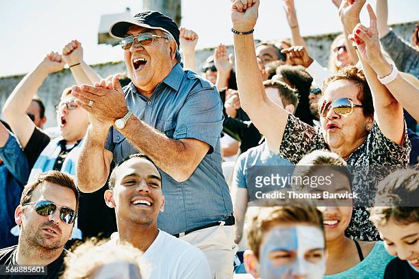 Senior couple cheering in stadium during match