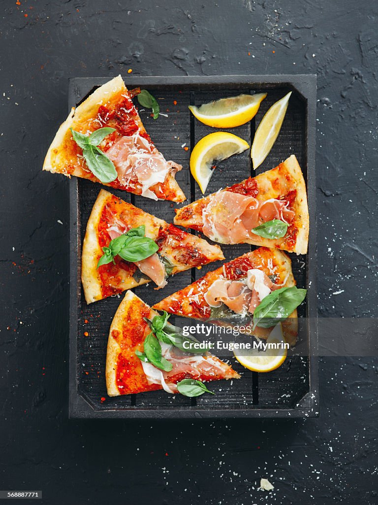 Pizza with prosciutto, basil and parmesan cheese