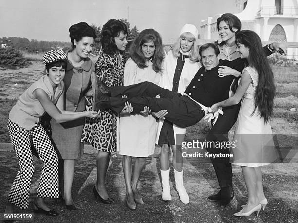 Portrait of Italian actor Ugo Tognazzi being held up by a group of actresses, Romina Power, Maria Capparelli, Maria Grazia Buccella, Monica Swers,...