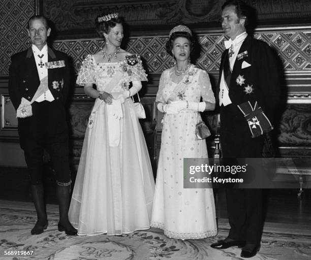 Queen Margrethe of Denmark and Queen Elizabeth II of Great Britain with their husbands, Prince Hendrik and Prince Philip , at a state banquet,...