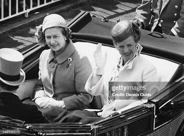 Queen Margrethe of Denmark waving as she rides in an open carriage with Queen Elizabeth II , on their way to Royal Ascot, England, June 17th 1980.