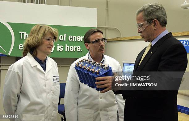 Glendale, UNITED STATES: US President George W. Bush holds a hybrid battery as he talks with engineer Mike Iverson and manager Joyce Kaiser during a...