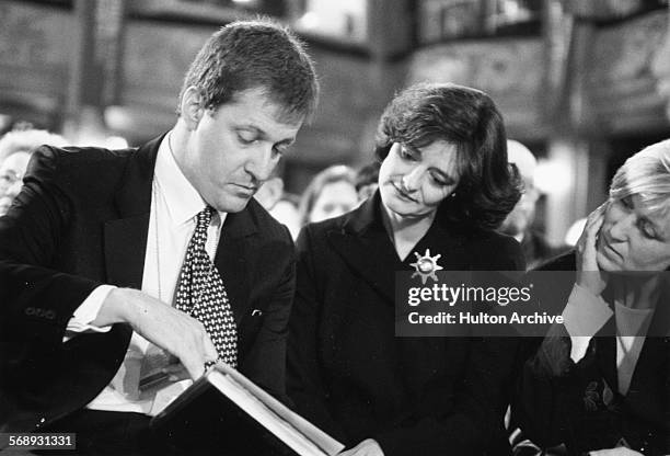 Labour Party political aide Alastair Campbell and barrister Cherie Blair, wife of Prime Minister Tony Blair, reading from a hymn book in church...