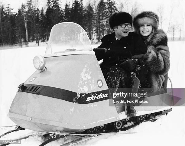 Actors Michael Caine and Francoise Dorleac riding a snow mobile during the filming of 'Billion Dollar Brain' in Helsinki, circa 1966.