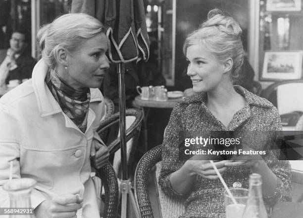 Actresses Ingrid Thulin and Yvette Mimieux chatting over a drink during a break in filming 'The Four Horseman of the Apocalypse', Paris, circa 1962.