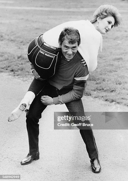 Celebrity hair dresser Vidal Sassoon lifting society model Francesca Thyssen on to his back, as they both model the new range of jeans designed by...