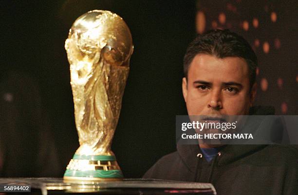 Los Angeles, UNITED STATES: A man stands before the FIFA World Cup Trophy on the first day of viewing at Universal Studios in Los Angeles, CA 20...